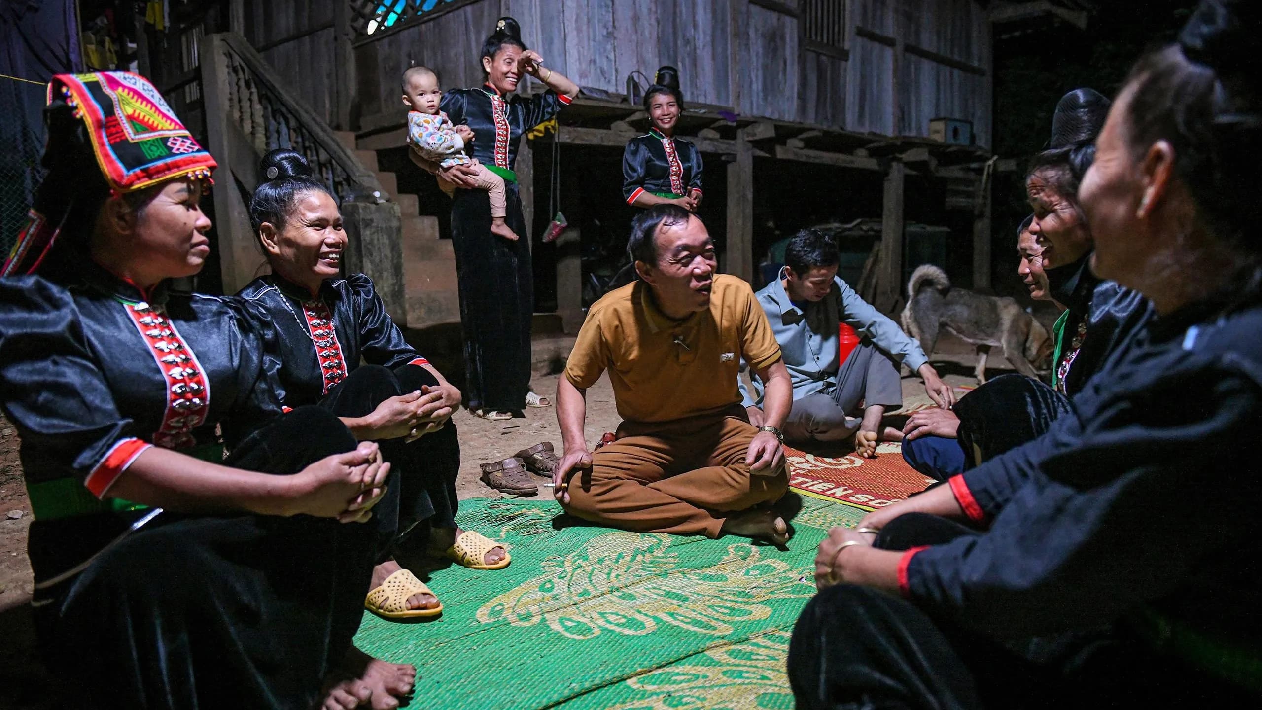 La Ha community gathers in a traditional stilt house setting.