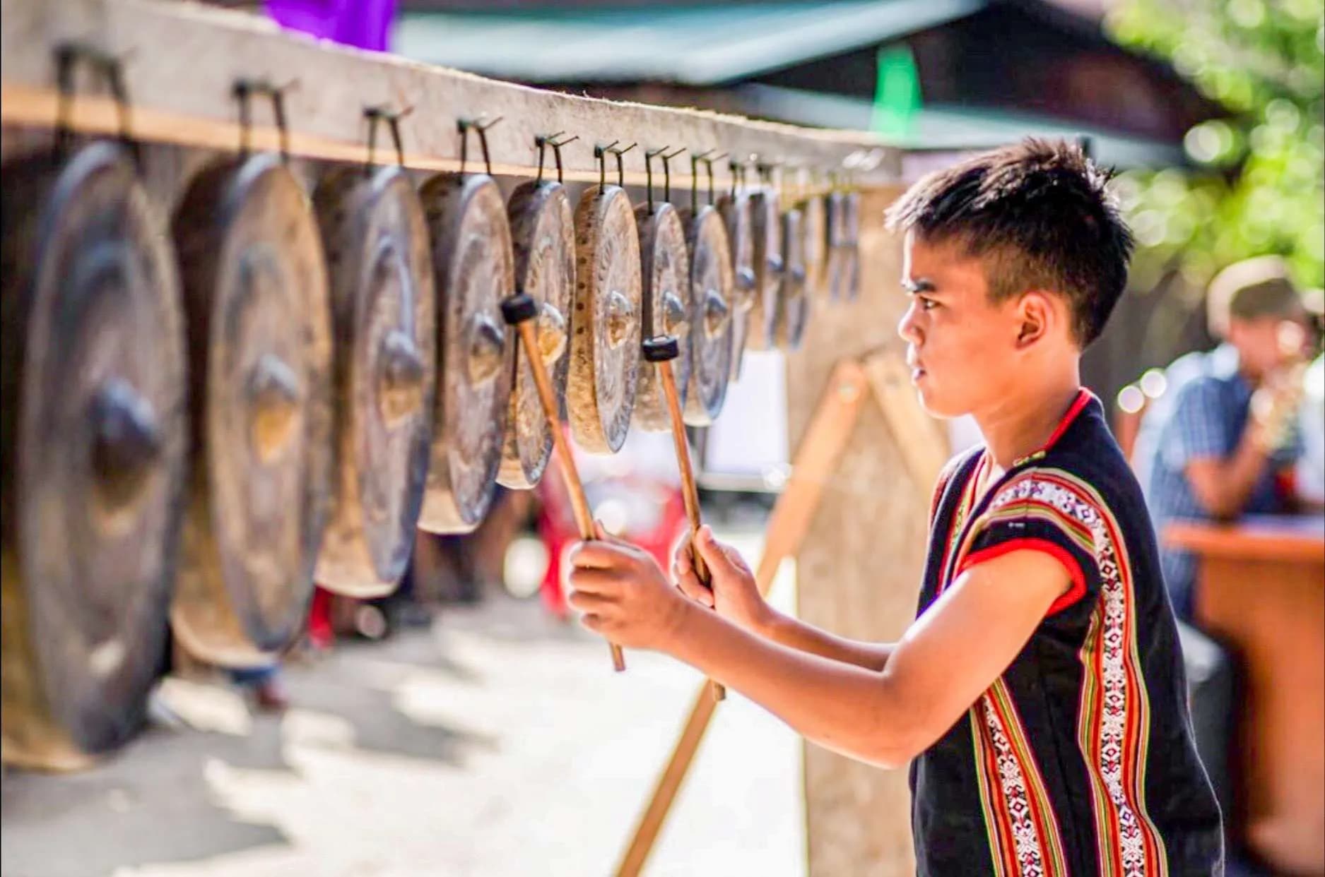 Xơ-Đăng man playing traditional gongs.