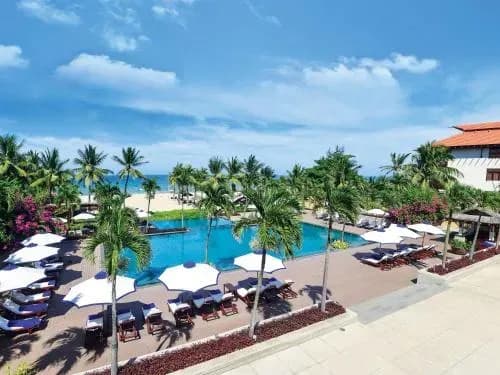 The pool at Furama Resort, a perfect relaxation spot with lush green scenery and the sea.