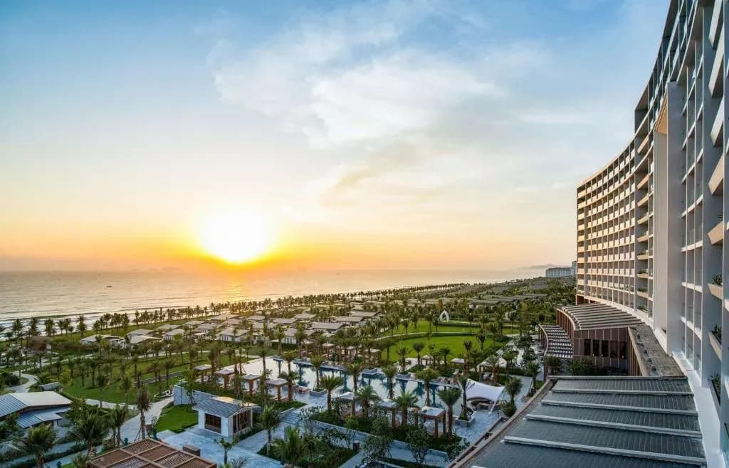 The magnificent sunrise view from Radisson Blu Cam Ranh, with the shoreline and lush gardens in the foreground.