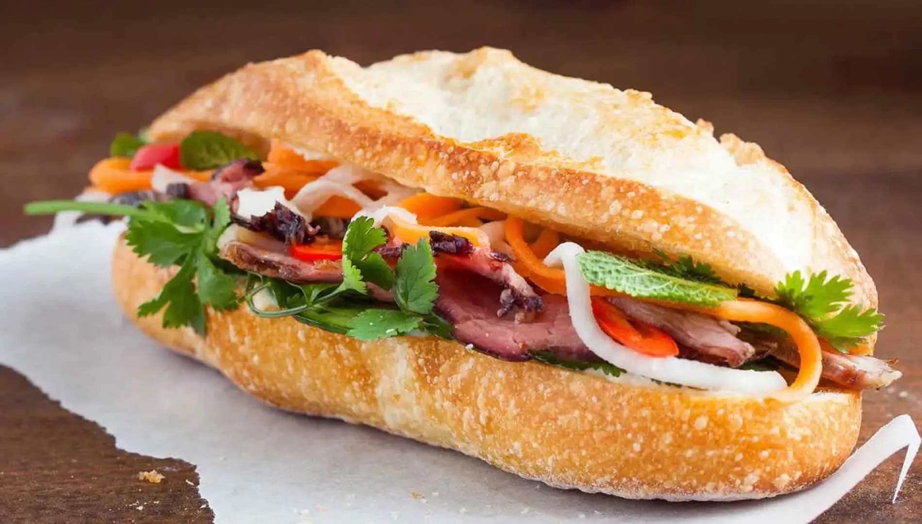 Banh mi Saigon, an iconic Vietnamese street food, is a perfect combination of crispy bread and a variety of fillings such as cold cuts, pate, raw vegetables, and sauces. This dish brings a rich, attractive flavor, often enjoyed for breakfast or as a snack.