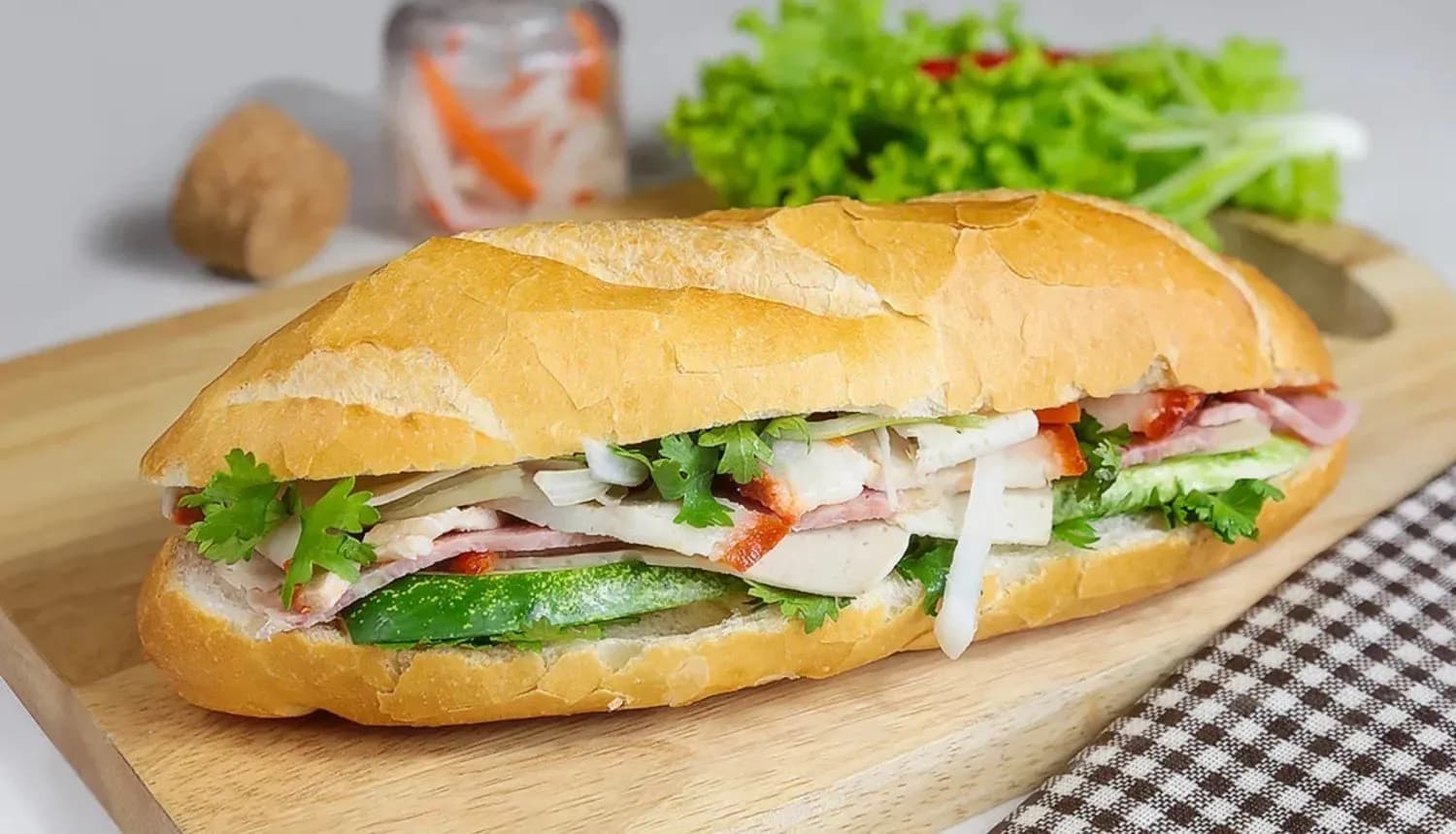 Banh mi Saigon, an iconic Vietnamese street food, is a perfect combination of crispy bread and a variety of fillings such as cold cuts, pate, raw vegetables, and sauces. This dish brings a rich, attractive flavor, often enjoyed for breakfast or as a snack.