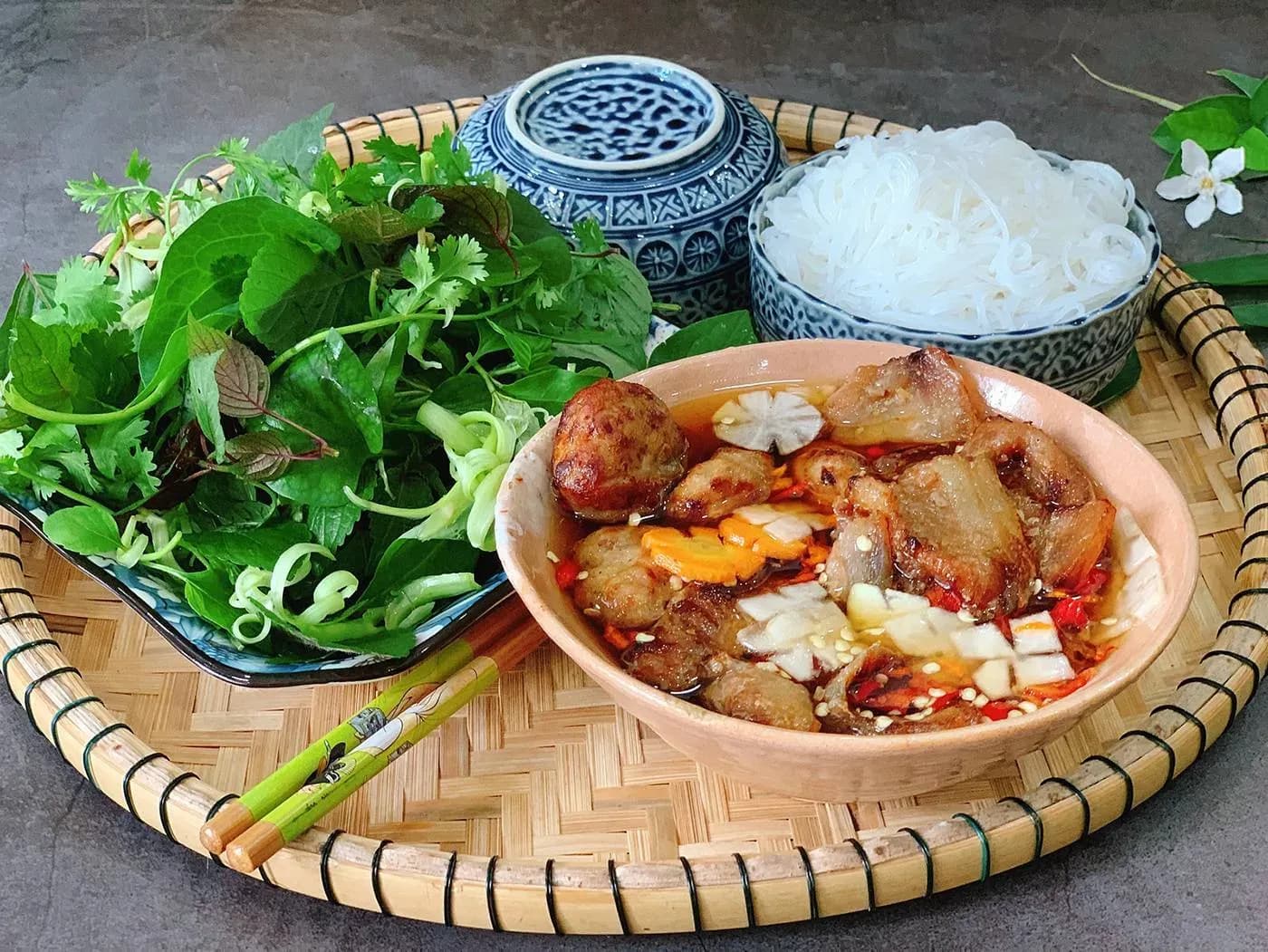 Hanoi vermicelli with grilled pork served with fresh herbs, a harmonious combination of grilled meat, fresh vermicelli and delicious raw vegetables, bringing a distinct Vietnamese flavor.