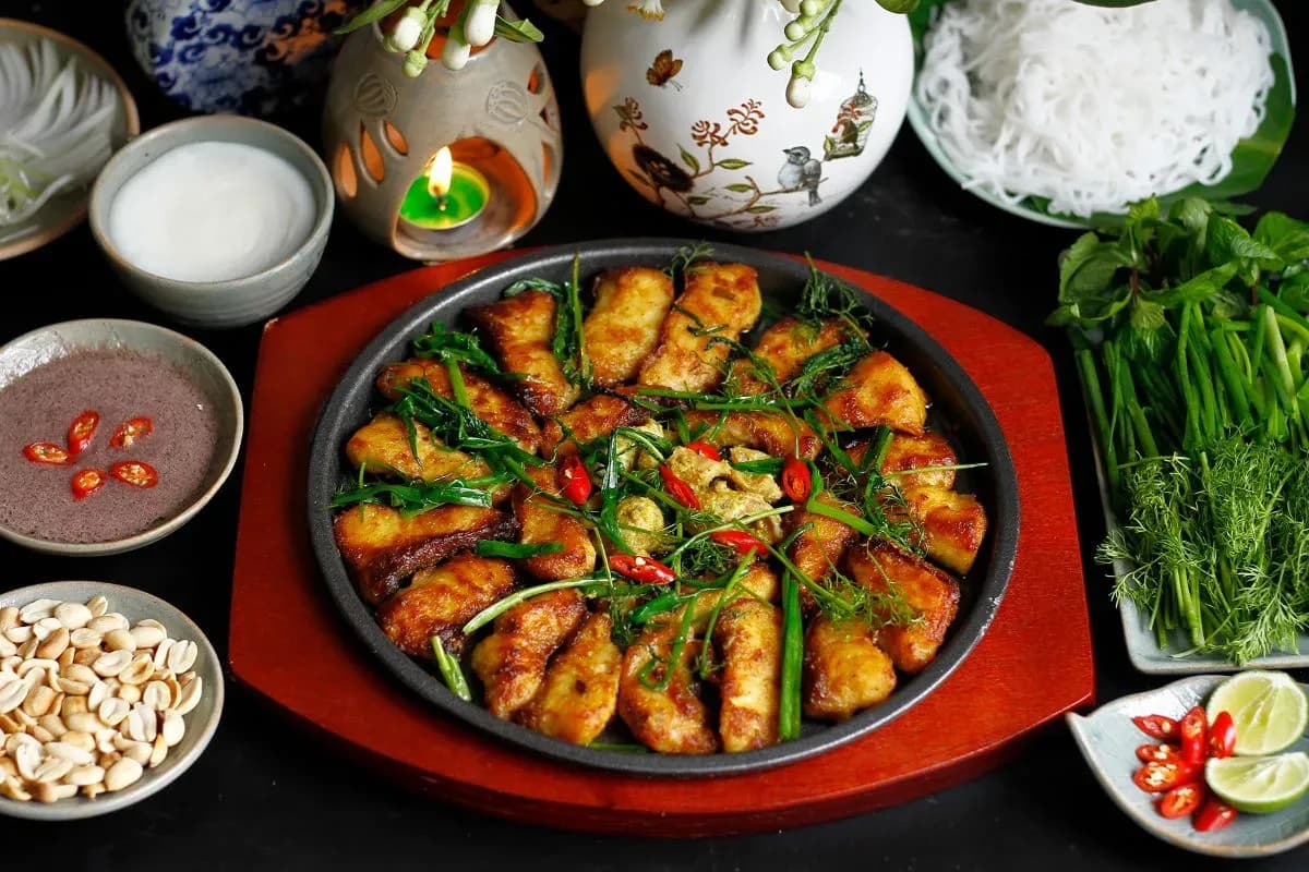 Cha ca La Vong is a famous Vietnamese dish, made from grilled fresh fish, often marinated with turmeric and dill, served with vermicelli noodles, peanuts and fresh herbs. This dish is a wonderful blend of flavors and textures, often enjoyed at the famous La Vong restaurant in Hanoi.