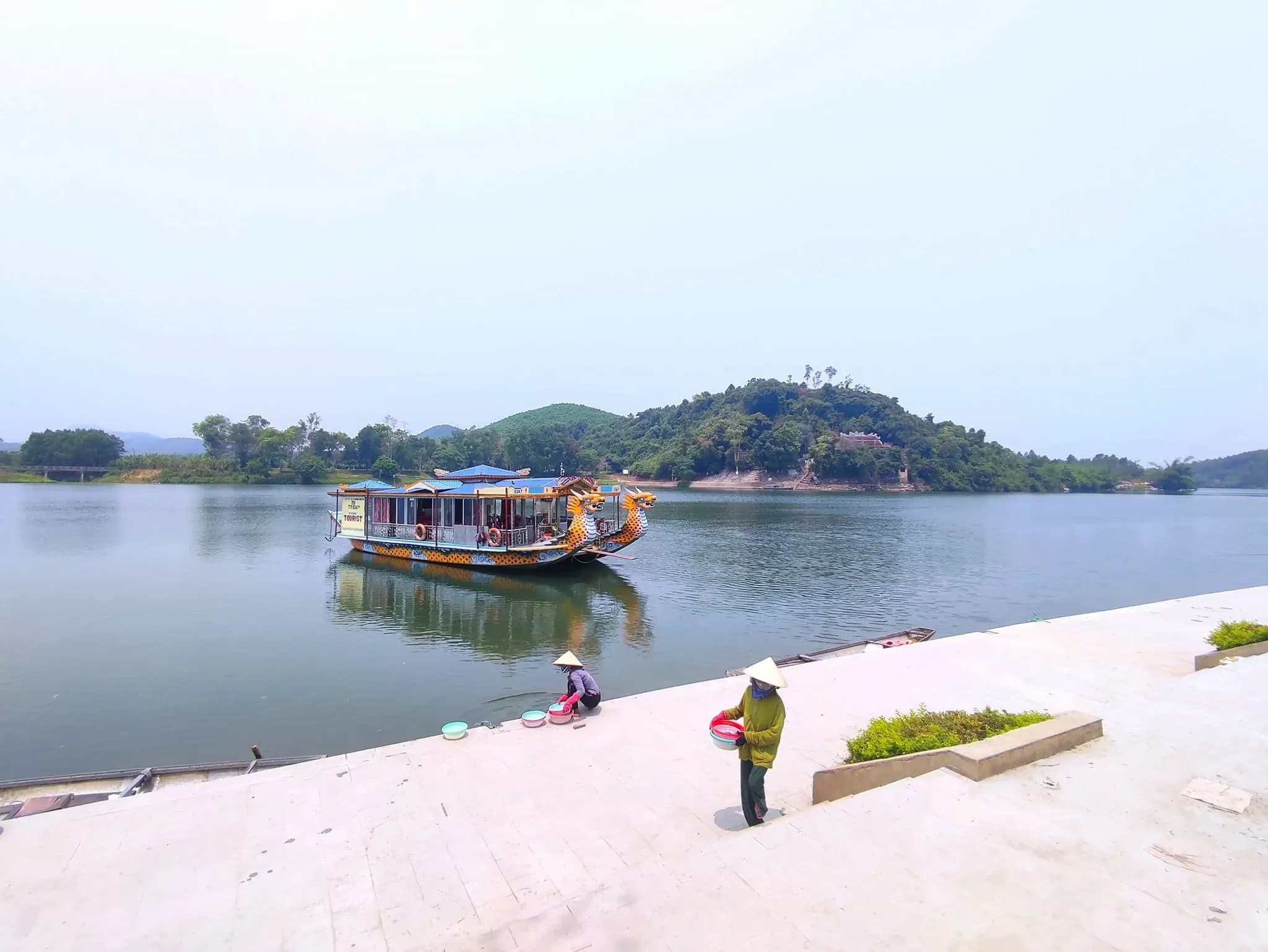 Dragon boat on the Perfume River in Hue, showcasing traditional Vietnamese craftsmanship against the serene river backdrop