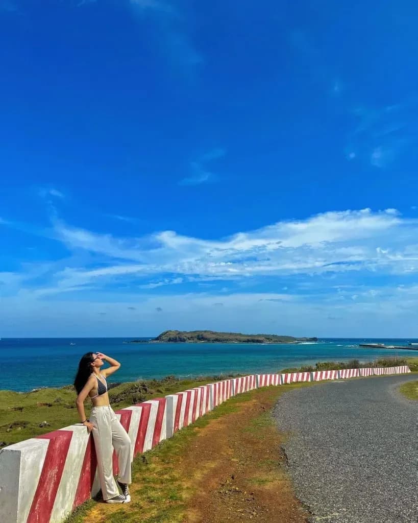 Tourists enjoy the clear blue sky and peaceful sea on Phu Quy Island