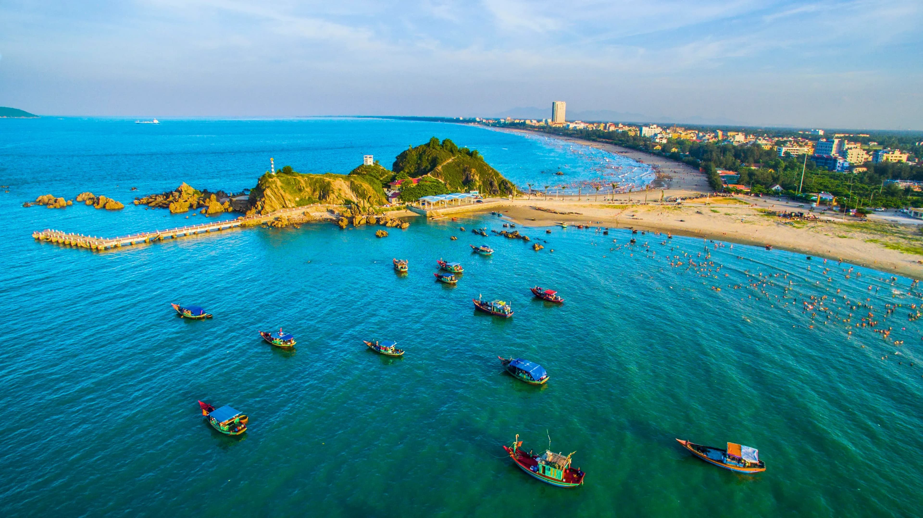 Vibrant Cửa Lò scene with vast blue sea and bustling boats.