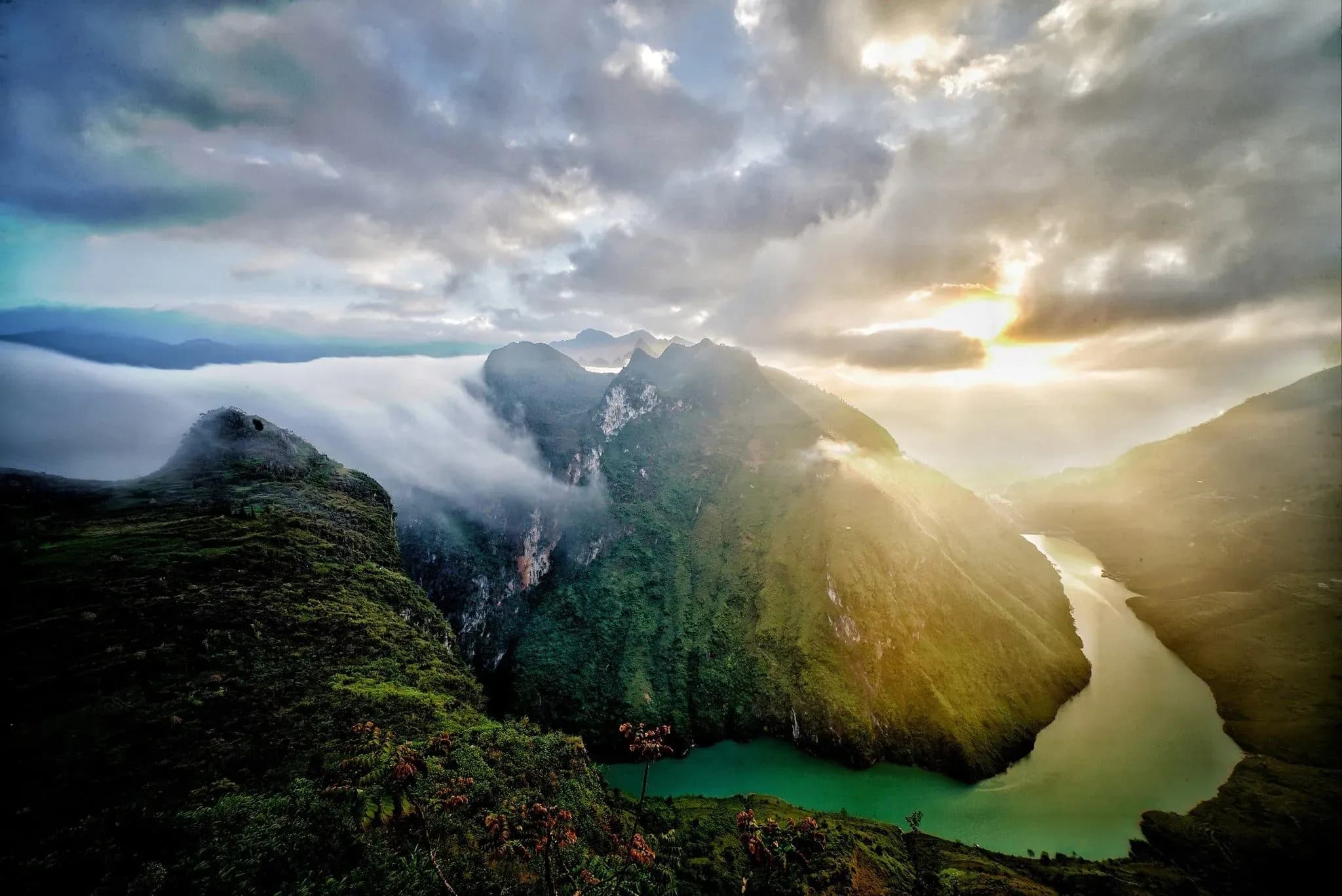 The Nho Que River, illuminated by warm sunlight and flanked by stunning limestone rocks