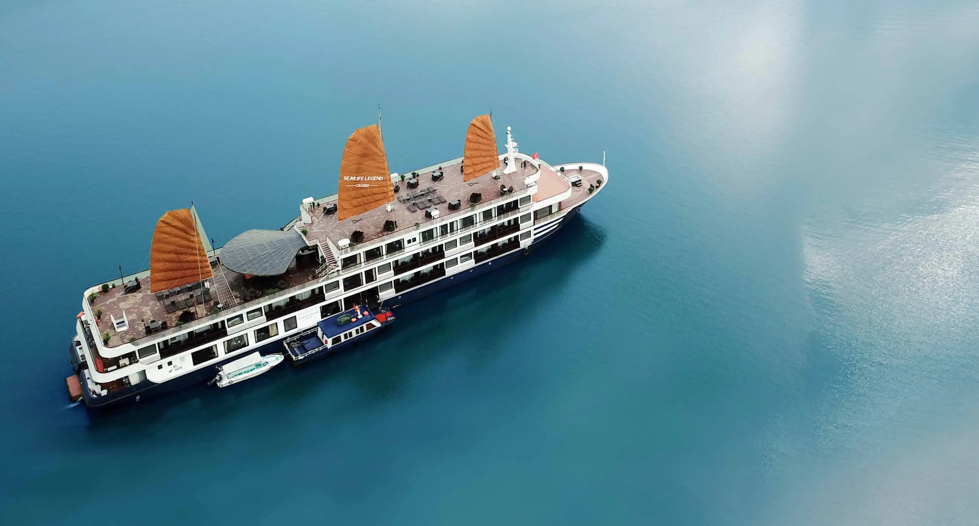 Cruise ship on deep blue water, viewed from above.