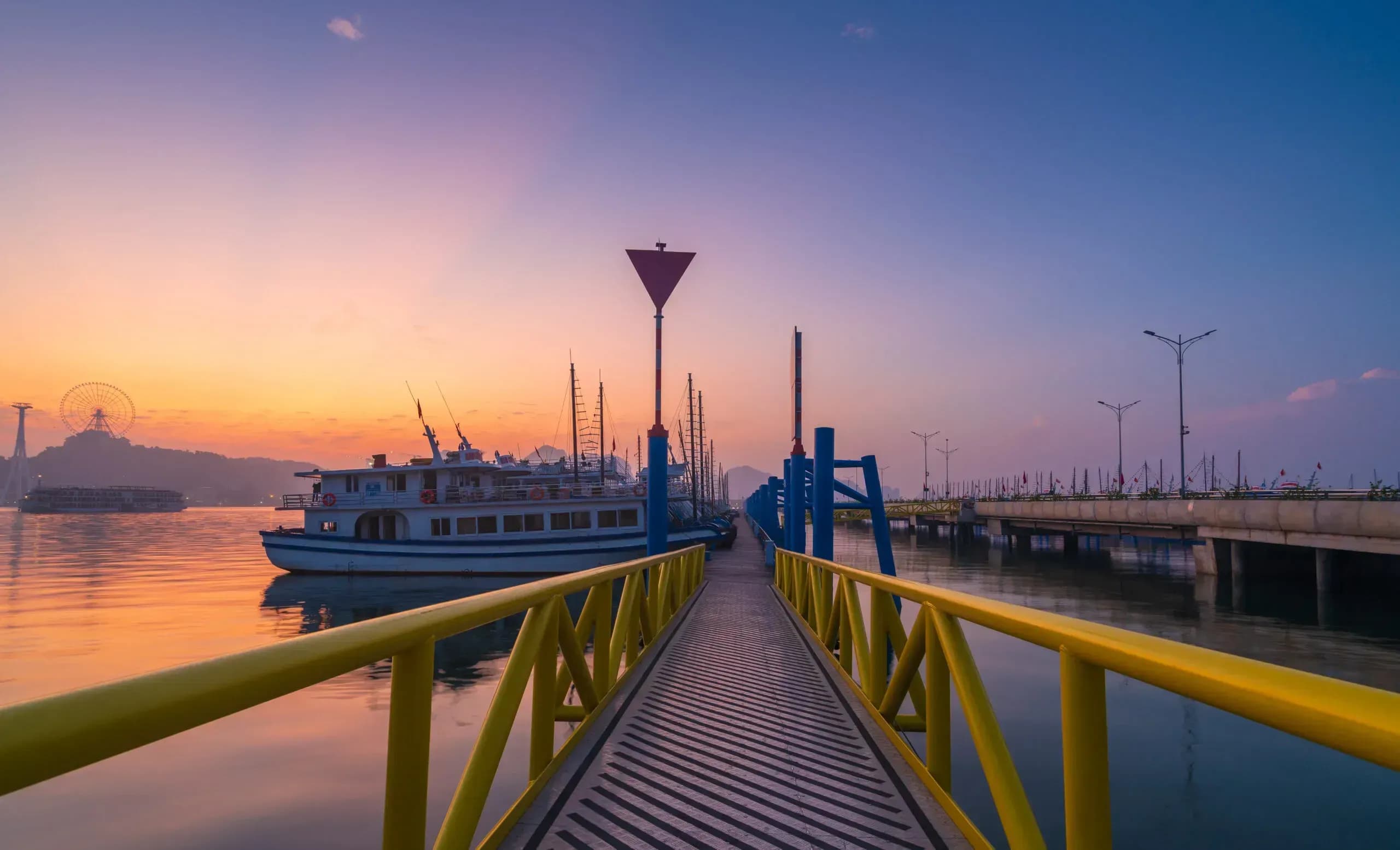 Pier with yachts at Halong Marina at sunset