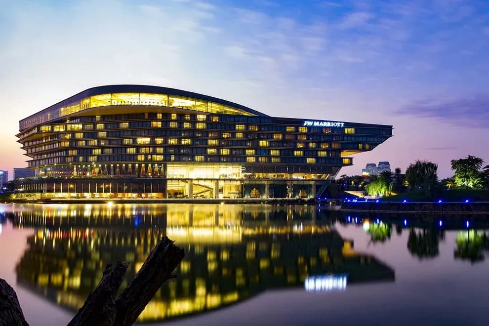 JW Marriott Hanoi Hotel reflects beautifully on the lake, glowing under the sunset.