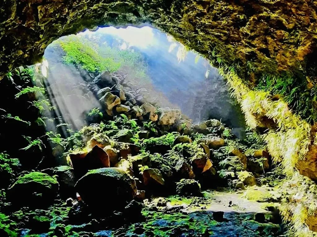Sunlight penetrates through the crevice in the volcanic cave, creating a spectacular view.