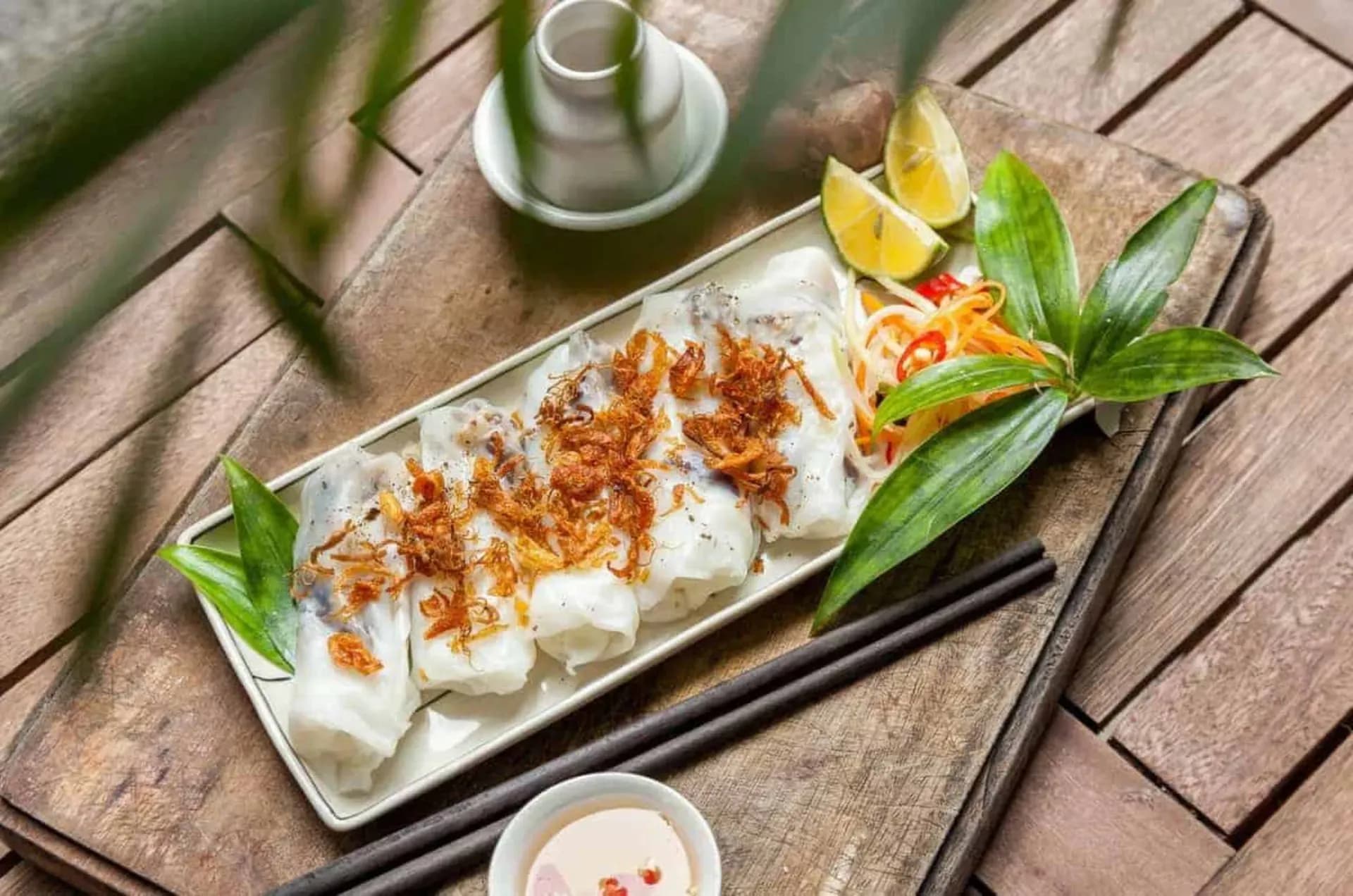 Thanh Tri rice rolls neatly arranged on a plate, topped with crispy shallots, ready to savor.