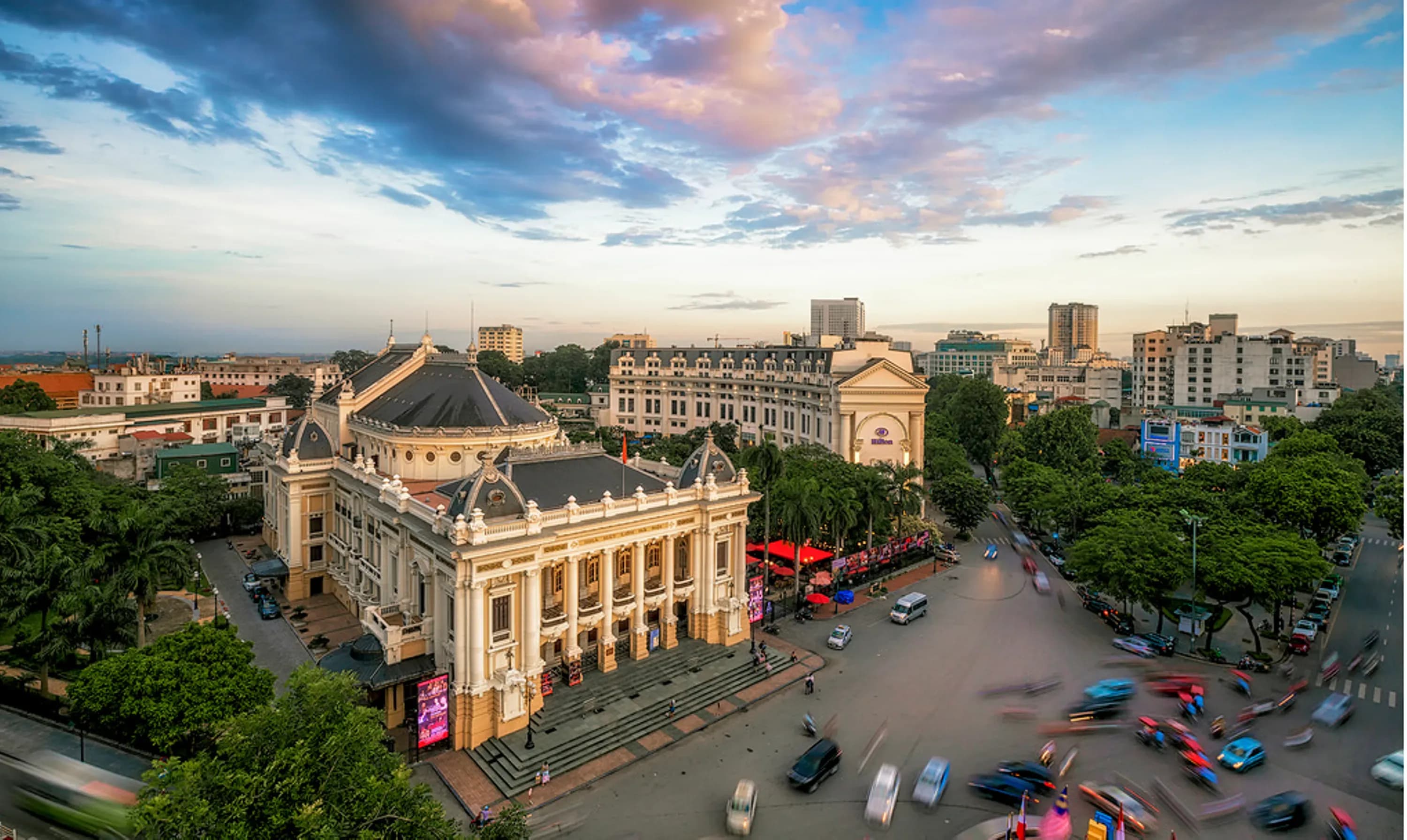 The Hanoi Opera House and Hilton Opera Hotel in a stunning sunset view.