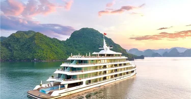 The Catherine Cruise ship glowing in Ha Long Bay at sunset.