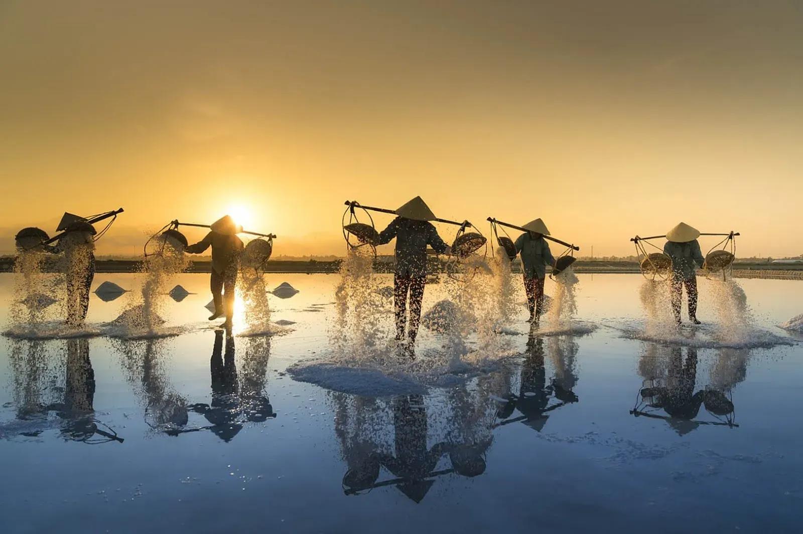 A salt dance under the sunset, with white grains gracefully tossed into the vibrant sky.