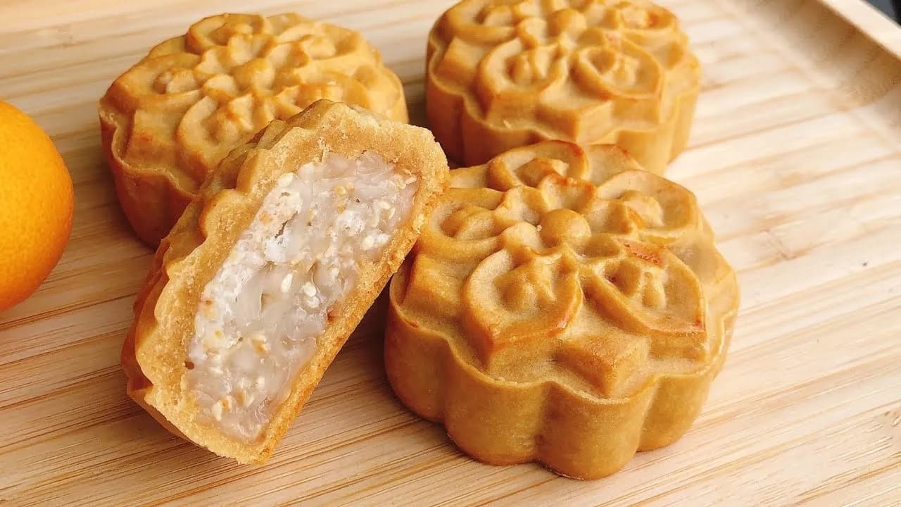 A selection of beautifully crafted mooncakes with intricate designs, featuring rich fillings like lotus seed paste, red bean, and salted egg yolk, displayed in celebration of the Mid-Autumn Festival.