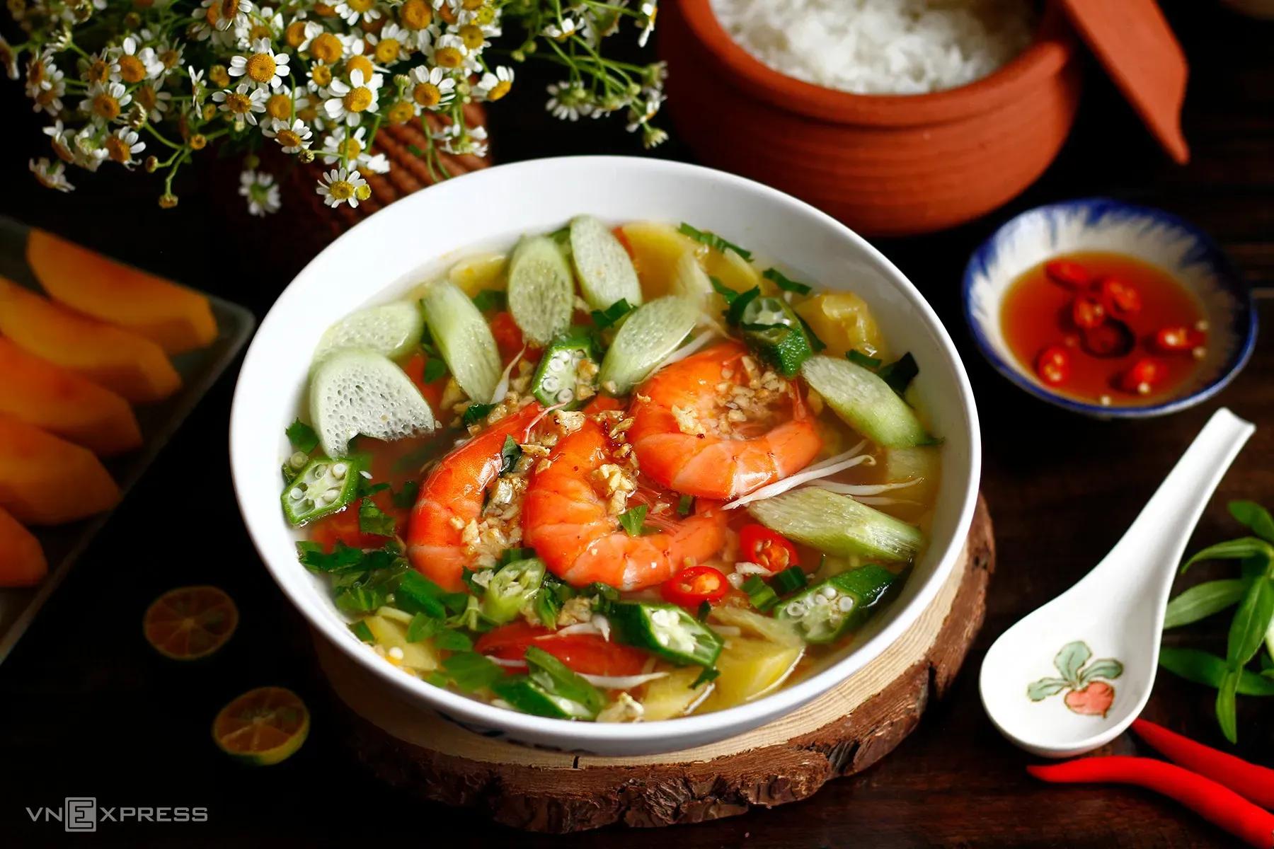 Colorful shrimp sour soup with fresh ingredients like okra, tomato, and pineapple.