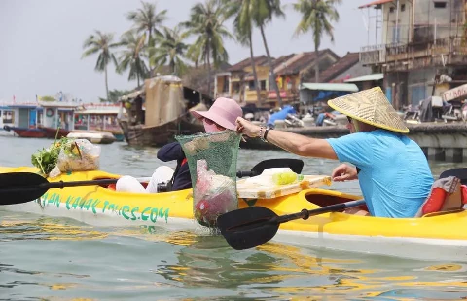 Kayakers on Hoai River actively collect trash, contributing to environmental protection in this meaningful journey.
