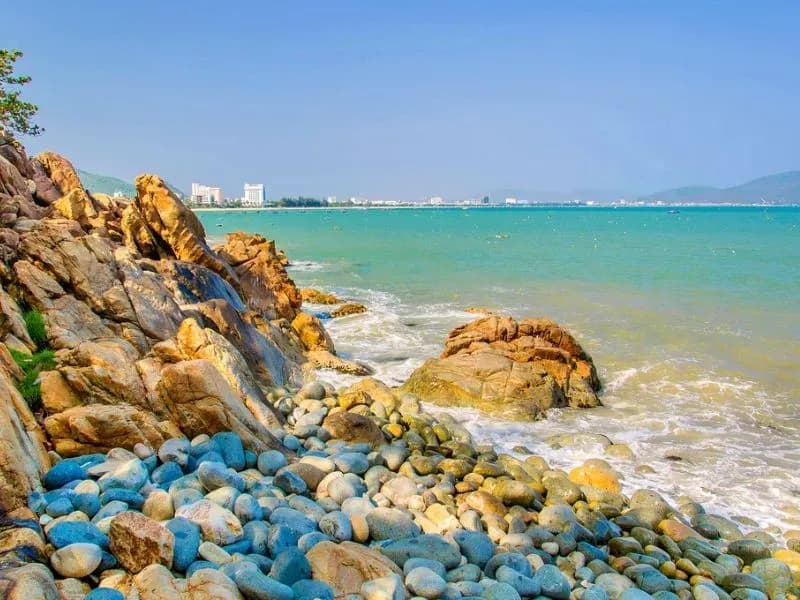 Queen's Beach showcases smooth round stones amid vibrant blue sea.