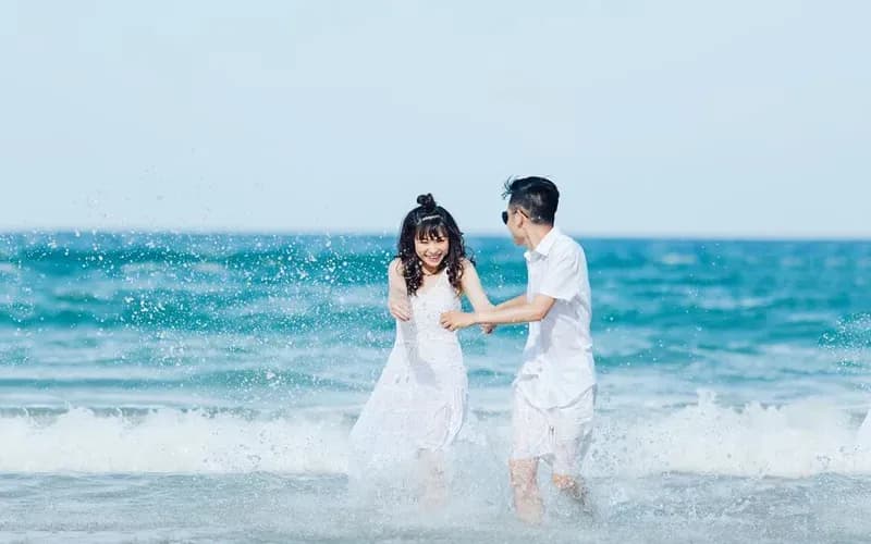 A couple enjoying playful moments at Bai Dai Beach, Nha Trang with crystal-clear water.