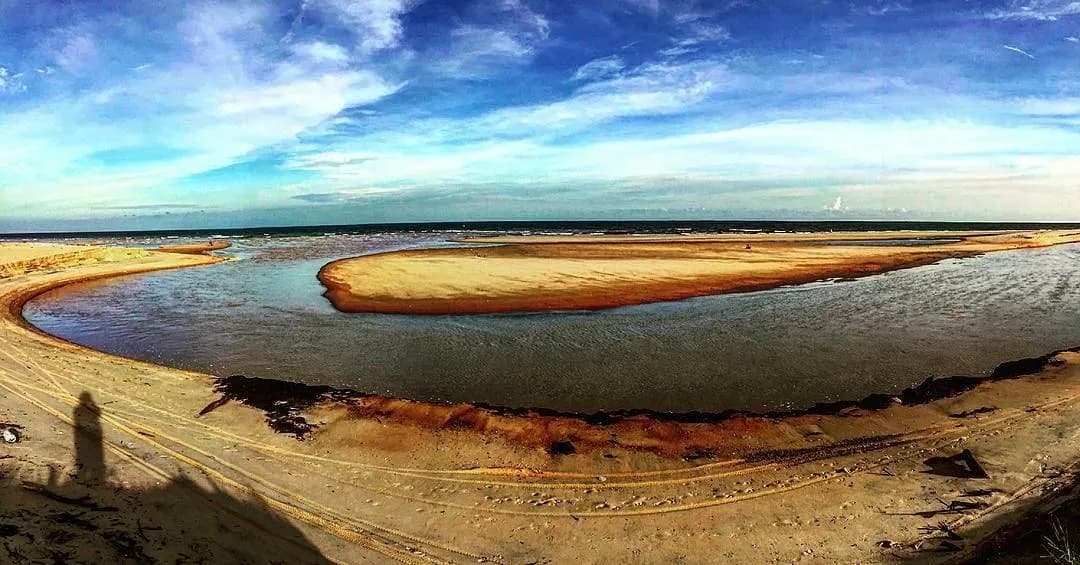 Winding white sands surround the stream, crafting a breathtaking natural scenery.