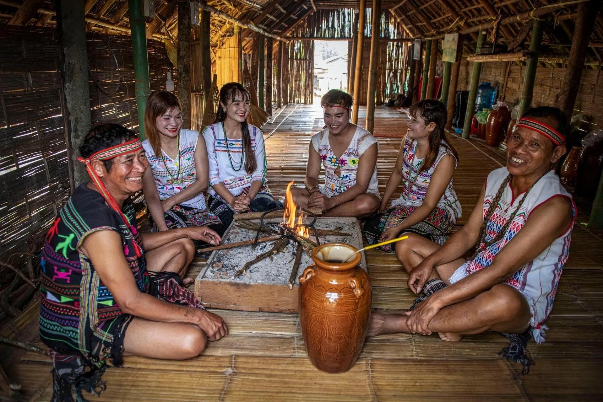 Ma people gathered around a fire in their longhouse.