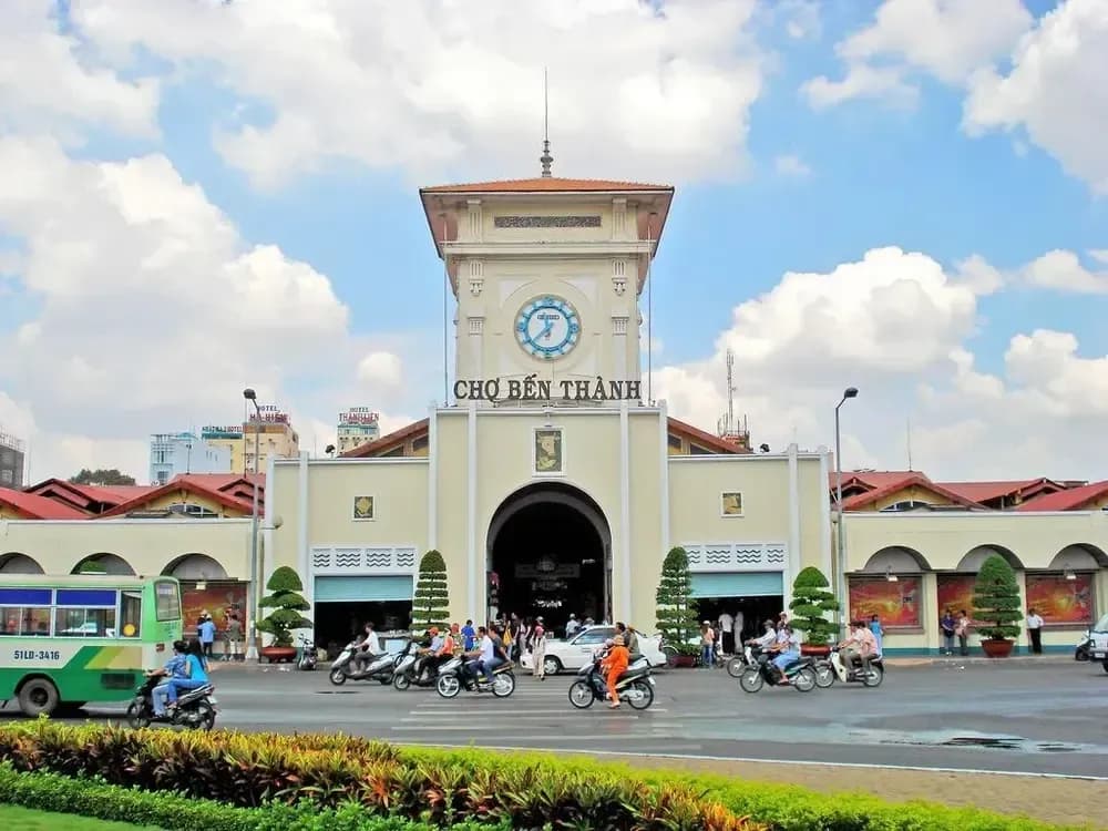 Moderne Aussicht auf den Ben Thanh Market, mit seinem ikonischen Uhrturm und belebtem Verkehr.
