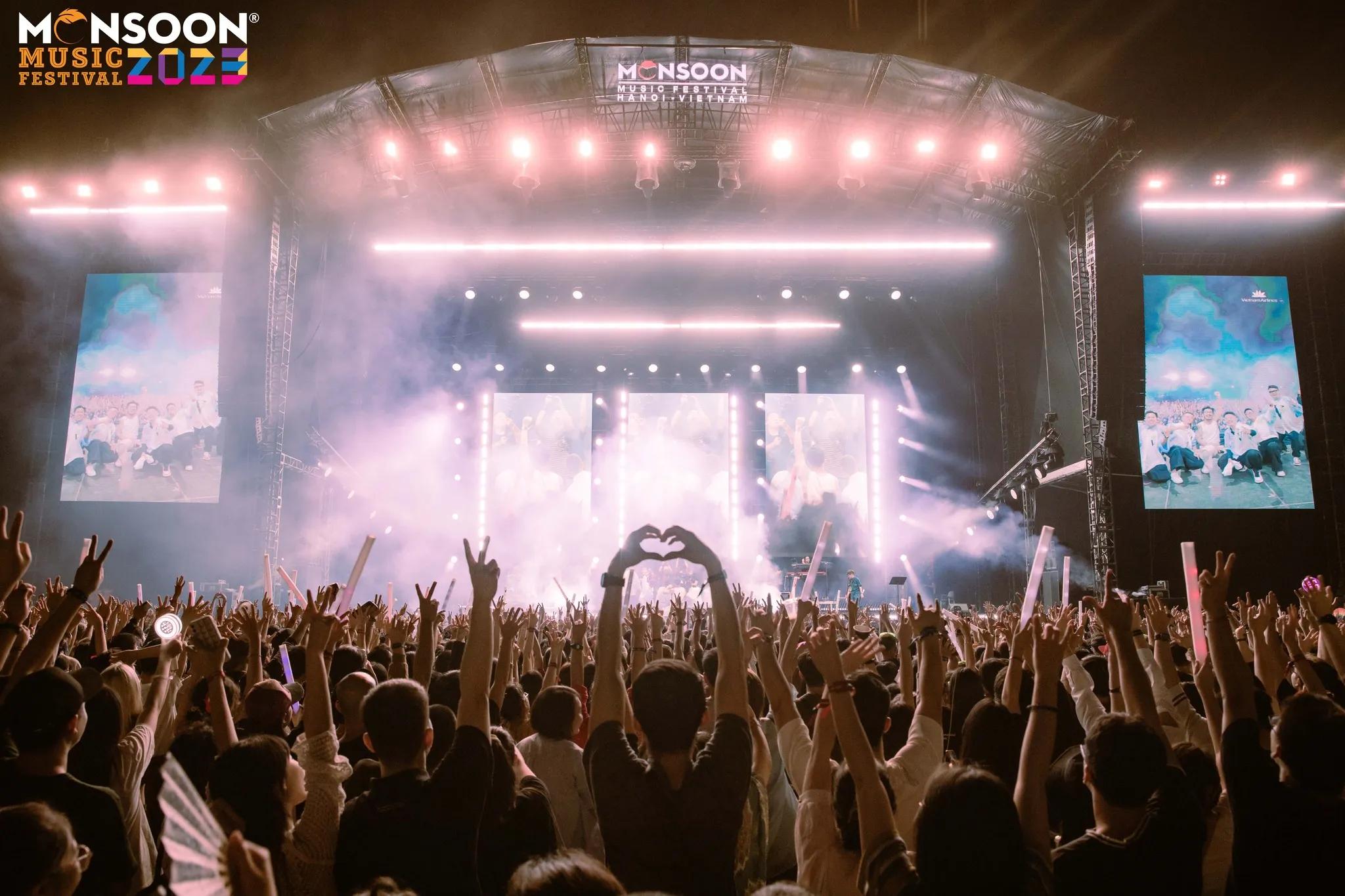 Monsoon Music Festival 2023 with a huge crowd and a brightly lit stage with many heart finger signs
