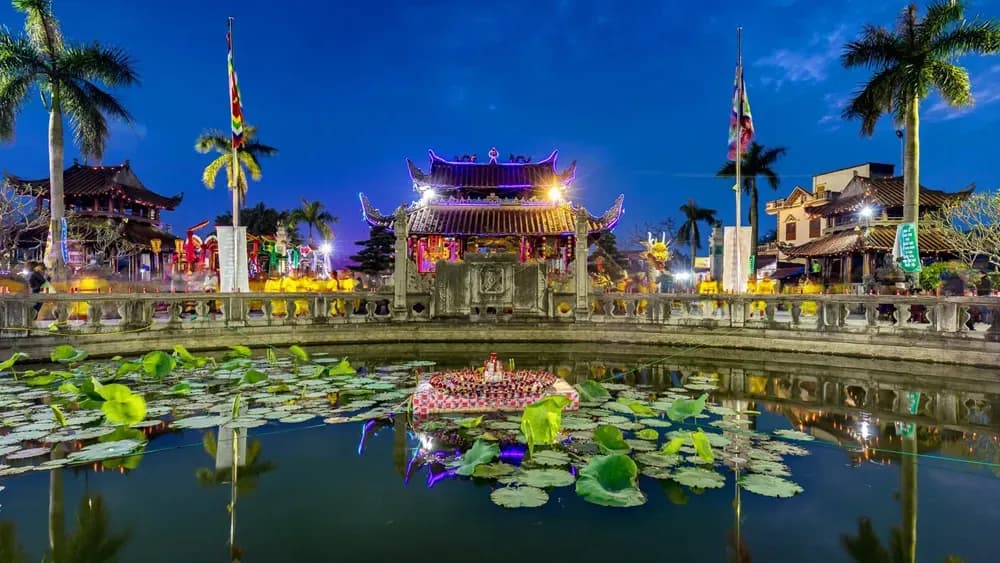 Lotus pond and temple architecture at Phủ Dầy, Nam Định, at night.