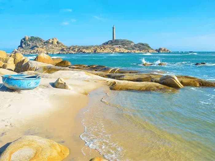 Rocky shore with blue sea in Phan Thiet, featuring a majestic lighthouse.