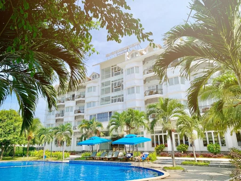 Poolside area and green landscape at Ben Tre Riverside Resort.