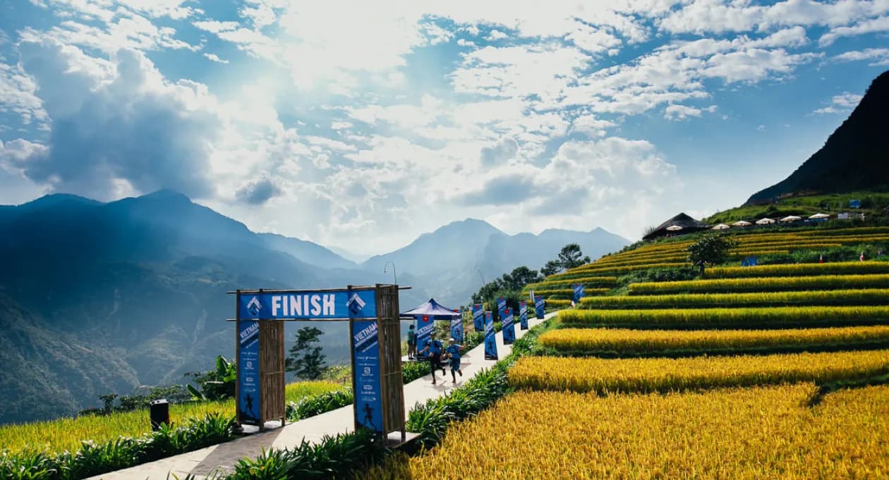Runners participate in an ultra trail marathon in Vietnam, navigating challenging terrain through lush forests, steep hills, and rugged mountain paths, surrounded by stunning natural landscapes