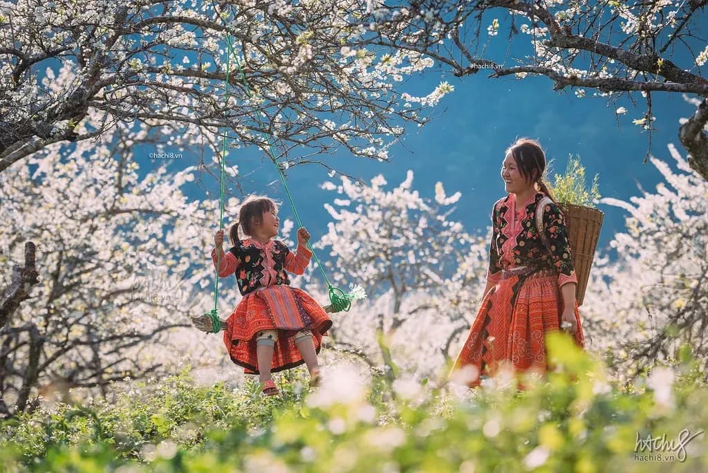 Spring scene with blooming plum blossoms, featuring a young woman and girl in traditional ethnic costumes.