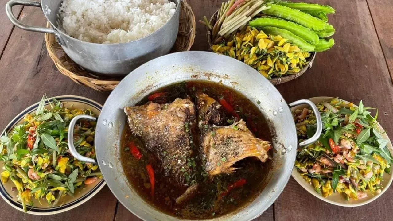 Un plat salé de poisson-chat braisé avec de l'eau de coco, servi avec du riz et des légumes.