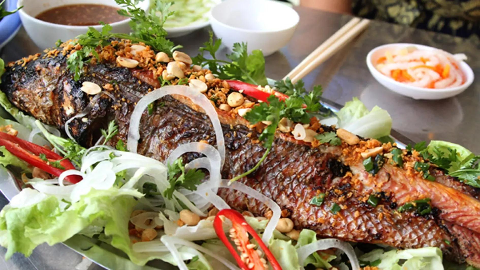 Grilled snakehead fish garnished with herbs and peanuts. This dish showcases the unique flavors of Southern Vietnam.