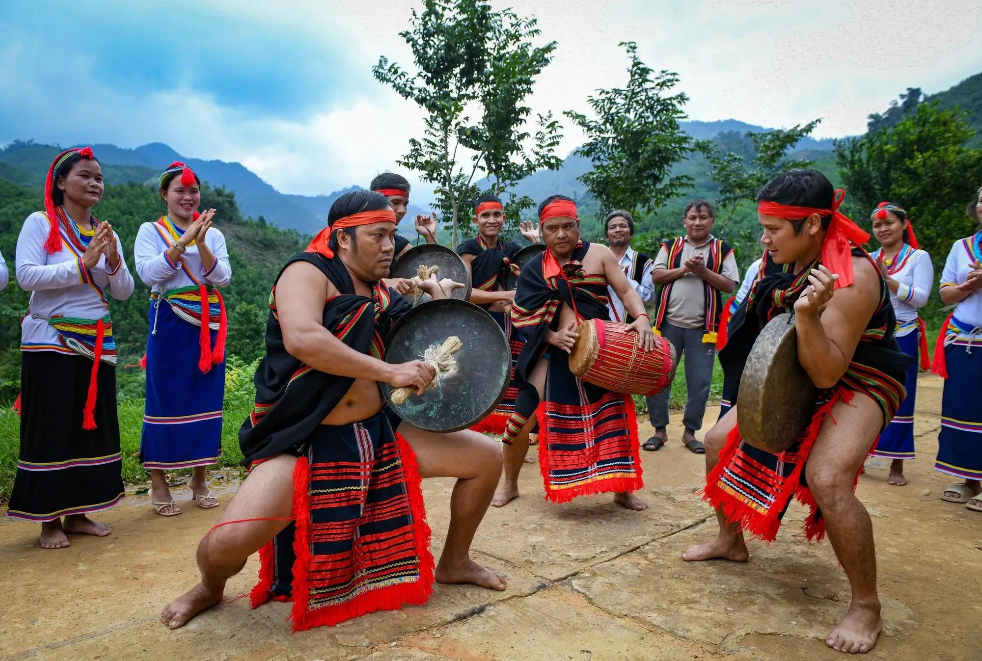 Traditional attire of the Co people with folk instruments.