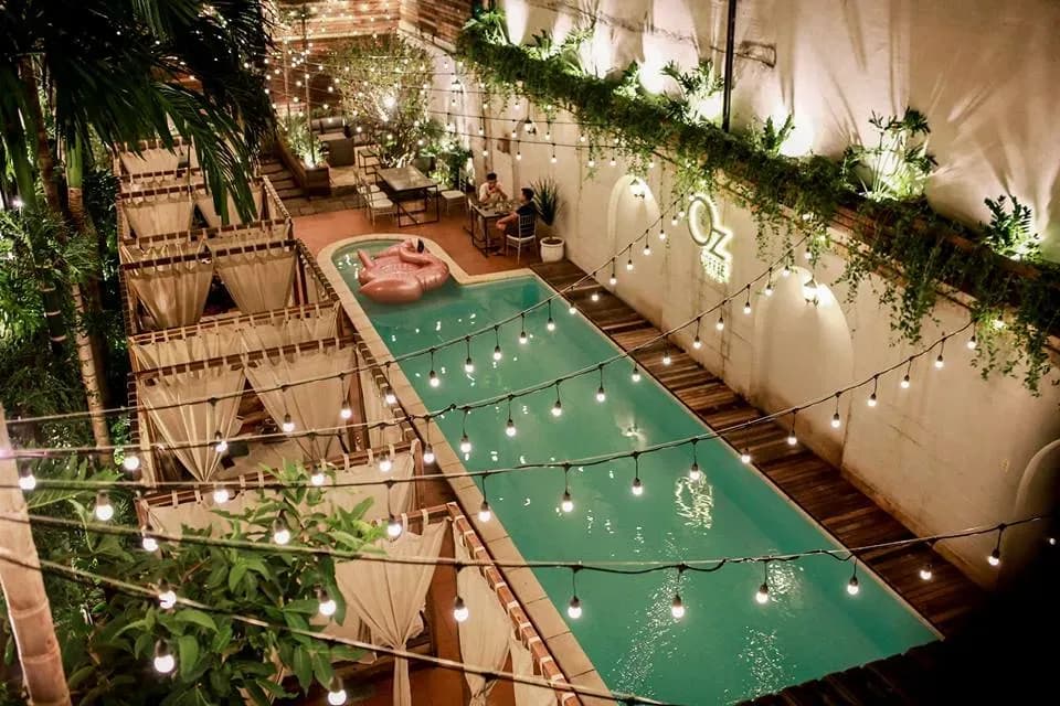 A cafe scene with a sparkling pool at night.