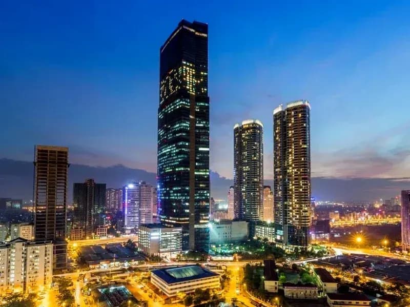 A towering skyscraper illuminated amidst the vibrant Hanoi cityscape.