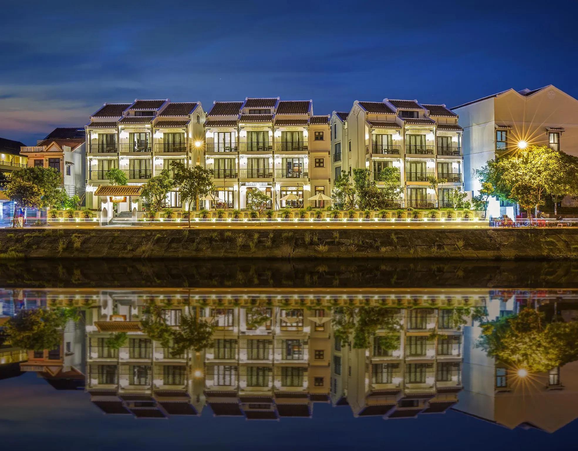 Little Riverside boutique hotel illuminated by Thu Bồn River's glow at night.