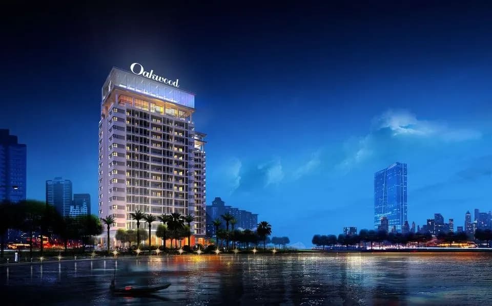 Oakwood Residence Hanoi building glowing brightly at night by West Lake.
