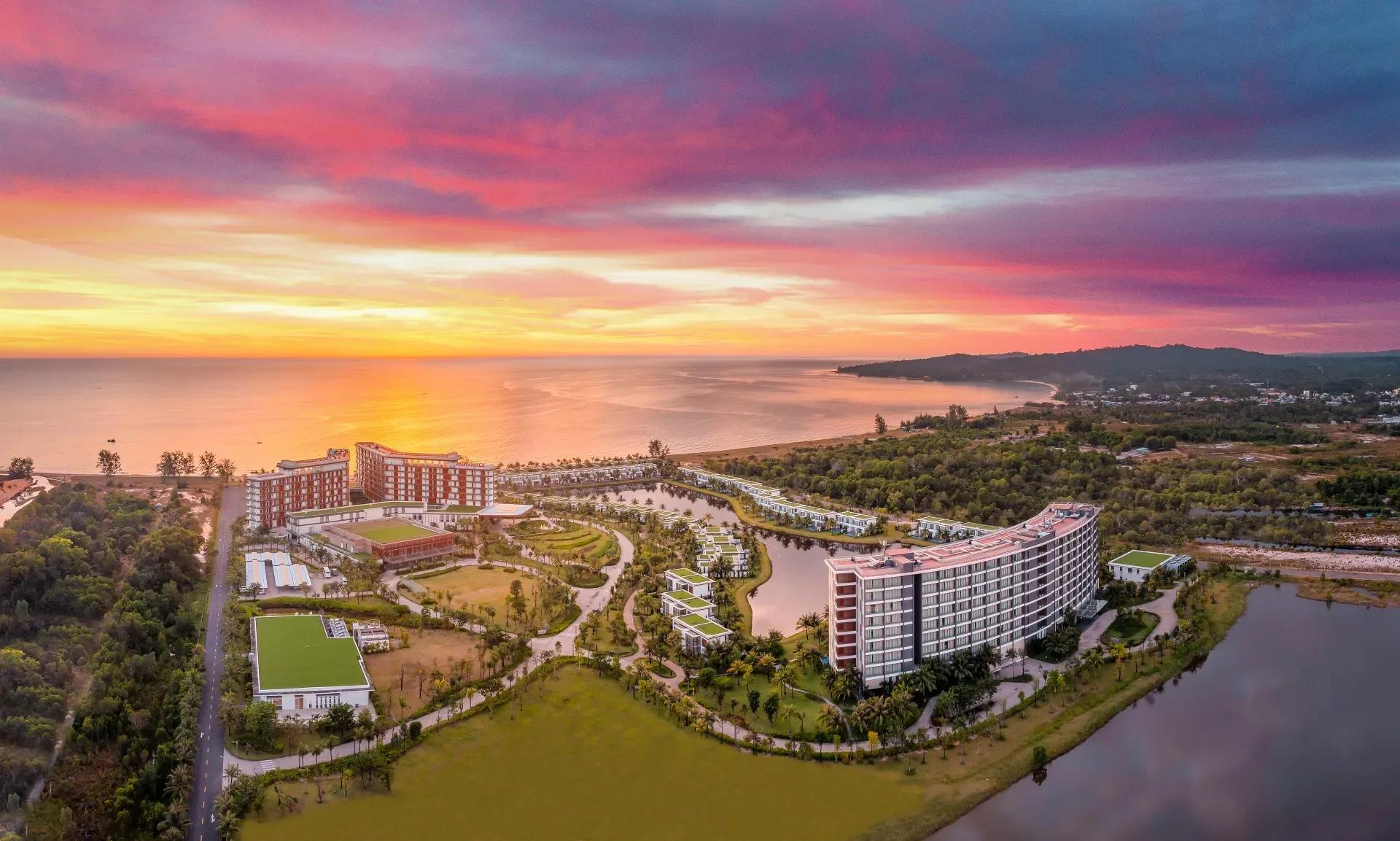The Mövenpick Waverly Phu Quoc Resort glows under a colorful sunset sky.