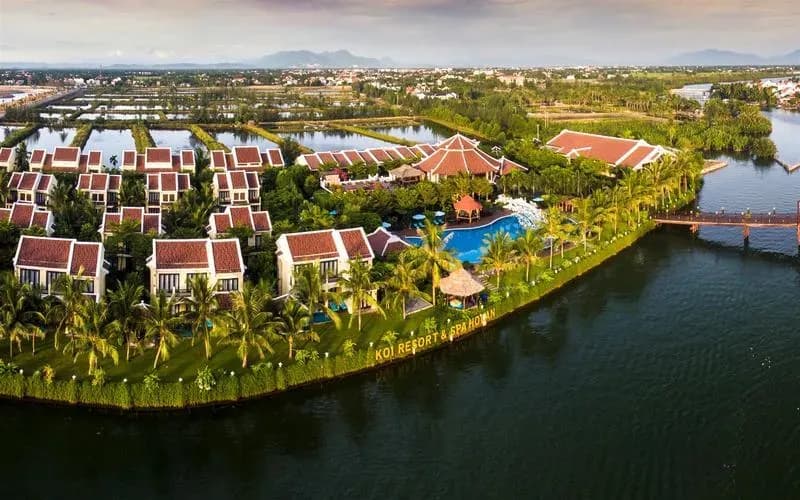 KOI Resort & Spa Hoi An nestled by the river, featuring luxury architecture blended with nature.
