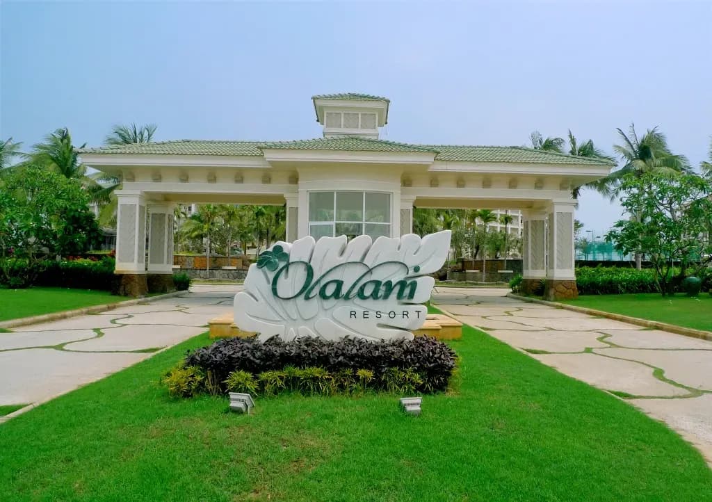 Entrance of Olalani Resort featuring modern design in lush greenery.